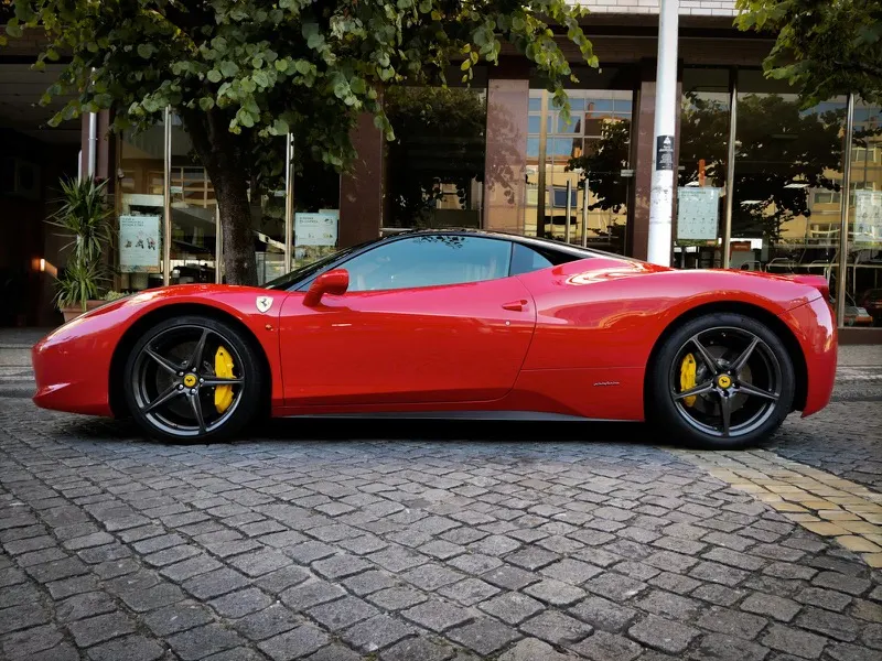 Ferrari 458 Italia in Rosso Corsa, side profile on cobblestone