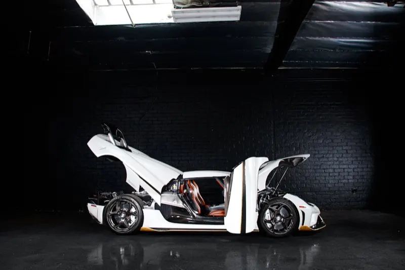 Koenigsegg Agera in pearl white with dihedral doors open, interior reveal under studio light