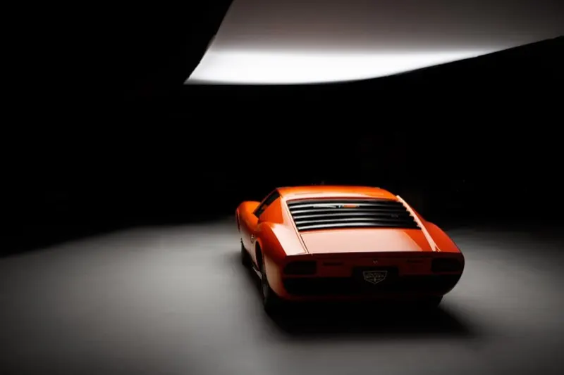 Lamborghini Miura SV in Arancio, three-quarter rear angle under studio lighting